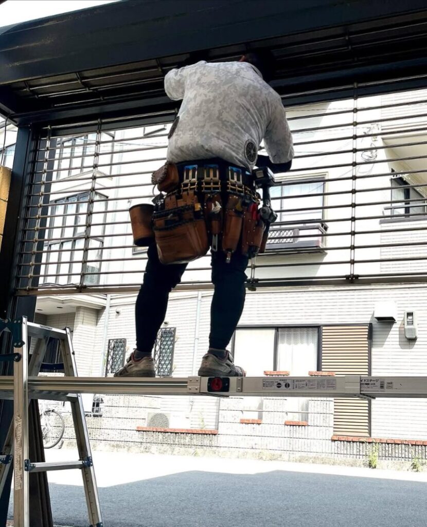 シャッターを修理している作業員